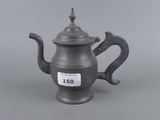 a silver teapot with a handle and a tag on it