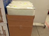 a stack of boxes sitting on the floor next to a refrigerator