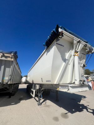 deux camions-bennes garés l'un à côté de l'autre sur un parking