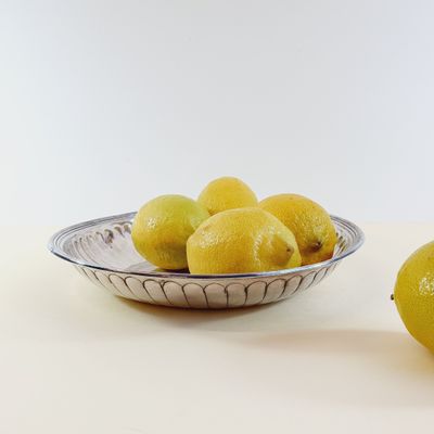 a bowl of lemons next to a bowl of lemons on a table