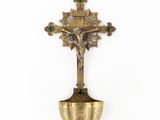 an antique brass crucift with a cross and a green bead