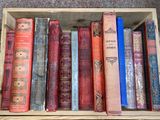 many old books in a wooden box on the floor