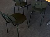 des tables et des chaises dans une salle de réunion, avec un ordinateur portable posé sur la table