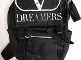 Le sac à dos est noir et comporte un « V » blanc.
