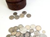 une petite boîte en bois contenant beaucoup de pièces de monnaie
