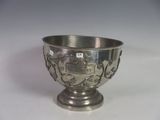 a silver bowl with a design on it on a white surface