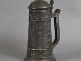 an antique pewed beer mug with a handle on a gray background