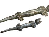 two metal alligators that are sitting next to each other