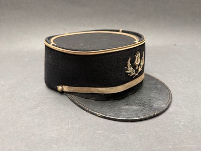 chapeau noir avec une bordure dorée sur fond gris