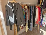 beaucoup de vêtements suspendus à un portant dans un placard
