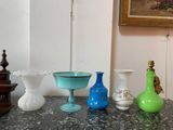 four vases on a table with a painting in the background