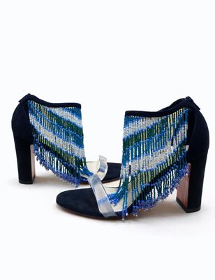 le talon d'une femme portant une paire de chaussures bleues et vertes