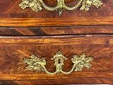 une commode ancienne en bois, ornée de ferrures en laiton sur le dessus