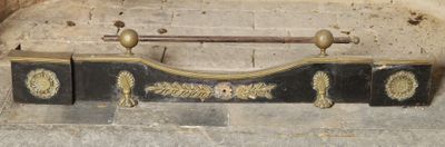 un porte-manteau noir et doré fixé à un mur en briques