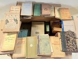 many old books stacked on top of each other on a table