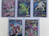 four different pokemon cards in a plastic case on a white surface
