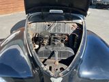 an old car with the hood up and the engine in the trunk