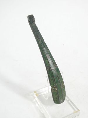 a green pipe sitting on a clear stand on a white surface