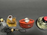 three perfume bottles and a hat on a table