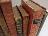 several old books are stacked on top of each other on a table