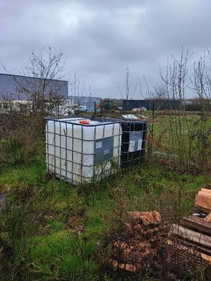 un grand conteneur posé au milieu d'un champ