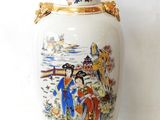 a vase with a painting on it sitting on a table