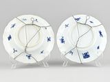 pair of blue and white plates on stands with wire around them