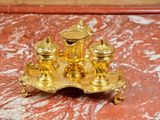 a gold plate with a candle holder on top of it