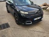 La voiture noire est garée devant un immeuble blanc.