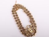 a gold plated necklace with flowers and leaves on a white background