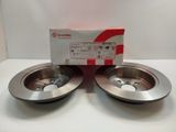 a pair of brake discs on a white surface with a box