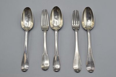 four silver spoons and a fork are lined up on a table