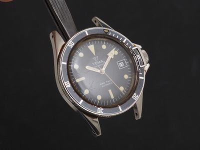 une personne tient une montre à la main sur un fond noir