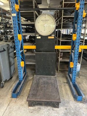 a close up of a large scale in a warehouse with lots of shelves