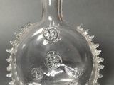 a clear glass bottle with a design on it