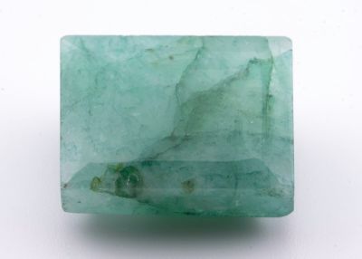 gros plan d'une pierre d'émeraude verte sur une surface blanche