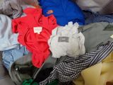 a pile of clothes sitting on a bed with a tag on it