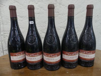 six bouteilles de vin sont posées sur une table devant un mur blanc