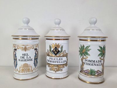 three white and gold canisters sitting on top of a white table