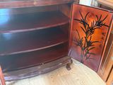 une armoire en bois dont la porte est ornée d'un tableau
