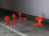 four red chairs are lined up in a row in an empty room