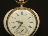 une montre de poche en or avec des chiffres romains