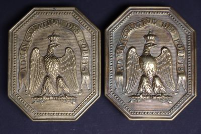 two silver medallions depicting an angel and a man