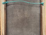 an old picture frame with a rope hanging from it ' s side