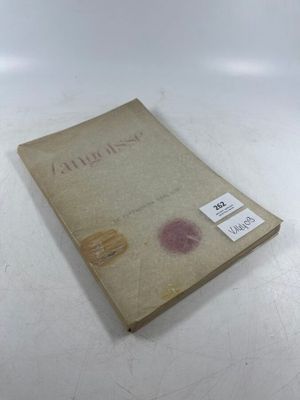 an old book sitting on top of a table with a tag on it