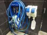 un tuyau bleu raccordé à des toilettes blanches dans une salle de bains