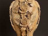 an old vase with a flower design on it sitting on a table