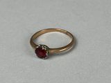 Gros plan sur une bague en or ornée d'une pierre rouge