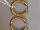 paire de boucles d'oreilles créoles plaquées or avec un fil blanc