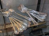 de nombreuses cuillères et fourchettes en argent dans une vitrine